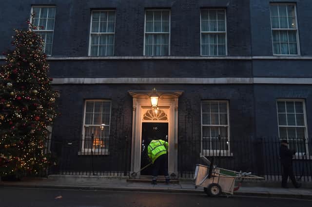 A man cleans the street in front of 10 Downing Street, London. The UK and European Union are on the threshold of striking a post-Brexit trade deal