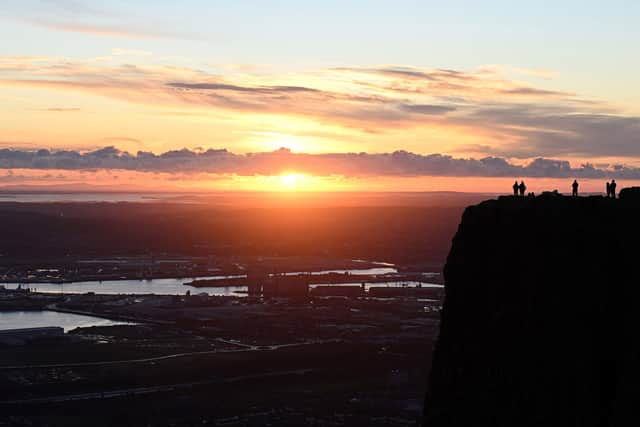 Walkers enjoy the view from Cave Hill as the the sun rises over Belfast, Northern Ireland at the start of the New Year. Picture: Michael Cooper