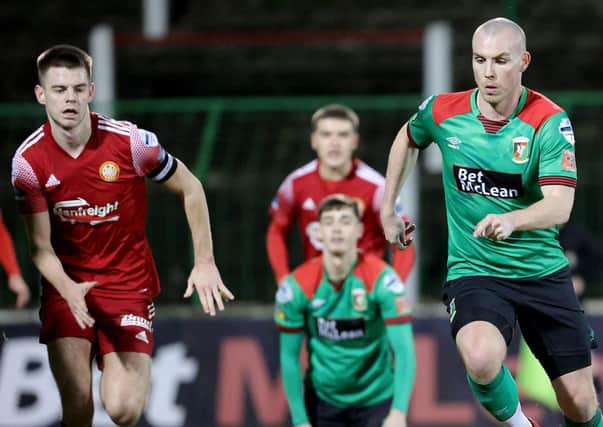 Luke McCullough on the attack for Glentoran as Ports captain Luke Wilson attempts to close in at The Oval. Pic by Pacemaker.
