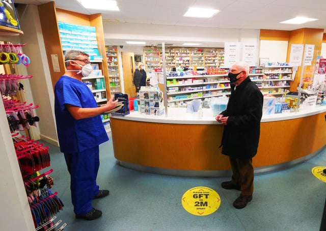 Chemist Andrew Hodgson (left) speaks to Robert Salt (centre), 82, as Covid jabs are given out in Macclesfield