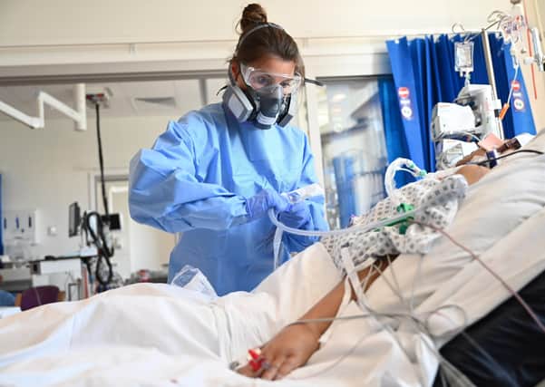Clinical staff wear Personal Protective Equipment (PPE) as they care for a patient at the Intensive Care unit at Royal Papworth Hospital on May 5, 2020 in Cambridge, England. (Photo by Neil Hall - Pool/Getty Images)