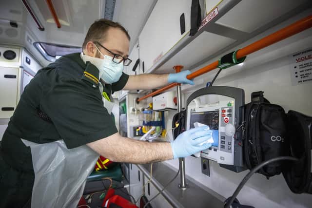 Paramedic Daniel McCollam wiping down a monitor in an ambulance after bringing a patient to Causeway Hospital during his shift for the Northern Ireland Ambulance Service covering the Northern Trust's Hospitals. Picture date: Monday January 18, 2021.