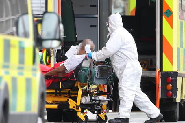 IMAGE PIXELLATED BY PA PICTURE DESK Paramedics transport a patient on a gurney from an ambulance
