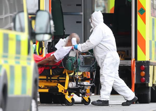 IMAGE PIXELLATED BY PA PICTURE DESK Paramedics transport a patient on a gurney from an ambulance