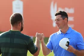 Tyrrell Hatton of England and Rory McIlroy of Northern Ireland bump fists on the 18th green during Day 4 of the Abu Dhabi HSBC Championship at Abu Dhabi Golf Club on January 24, 2021. (Photo by Andrew Redington/Getty Images).