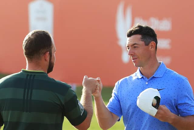 Tyrrell Hatton of England and Rory McIlroy of Northern Ireland bump fists on the 18th green during Day 4 of the Abu Dhabi HSBC Championship at Abu Dhabi Golf Club on January 24, 2021. (Photo by Andrew Redington/Getty Images).