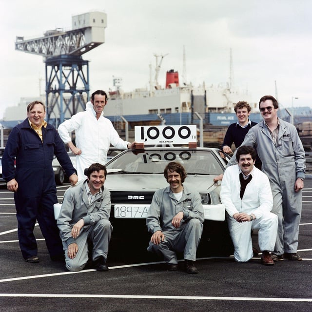 DeLorean employees pose with the 1,000th car to be shipped to the USA before loading onto the Pearl Ace at Belfast docks, 1981