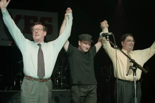 Ulster Unionist leader David Trimble (left), U2 singer Bono, and SDLP leader John Hume on stage for the 'YES' concert at the Waterfront Hall in Belfast in 1998, after the Good Friday Agreement. PA Picture by Brian Little/PA