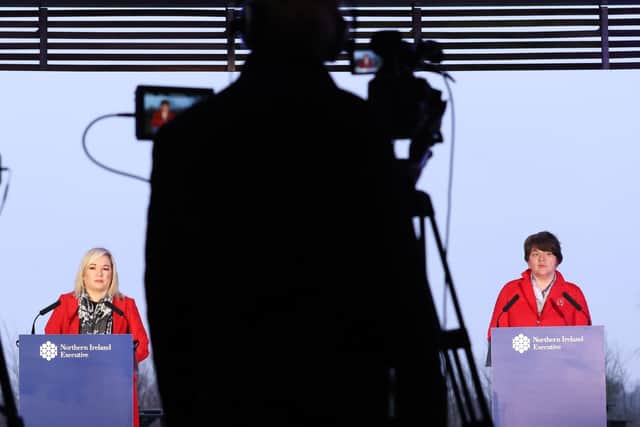 Michelle O'Neill and Arlene Foster, seen behind the silhouette of a cameraman
