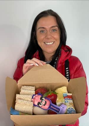 Kerri Wilson, of Board at Home, with one of the lunch boxes she is offering to those in need