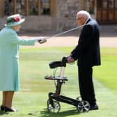 File photo dated 17/07/2010 of Captain Sir Thomas Moore receiving his knighthood from Queen Elizabeth II during a ceremony at Windsor Castle
