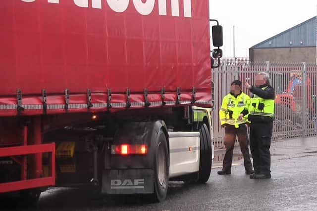 Border Force officers talk to a lorry driver at a checking facility near Belfast Port.