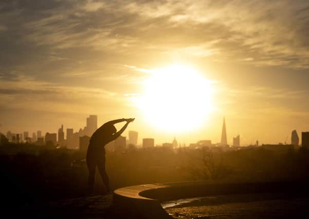 A woman performs yoga stretches on Primrose Hill, London as the sun rises over the city skyline last week. There wasn't much sun in Northern Ireland but the days are getting ever longer and brighter