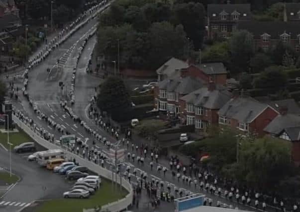 Wider angle images of the Bobby Storey funeal showed the event’s massive scale such as this clip from a Sinn Fein film showing marshals lined far along the route