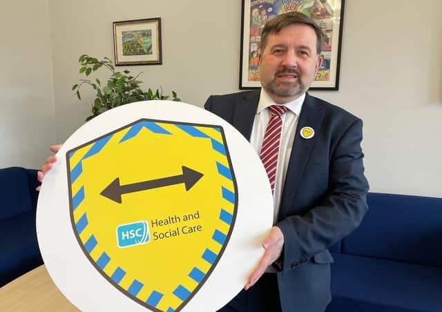 Health Minister Robin Swann shows off the new badge