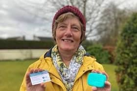 Christian Aid supporter Rachel McCormick holds her coronavirus vaccination card and a bar of soap to signify that soap and water remain among the few defences against infection for people in low-income countries until vaccines are made widely available