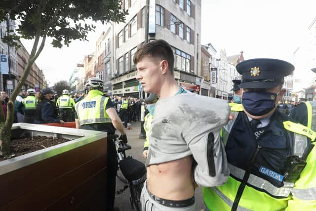 Gardai restrain a protester dring an anti-lockdown protest in Dublin city centre.