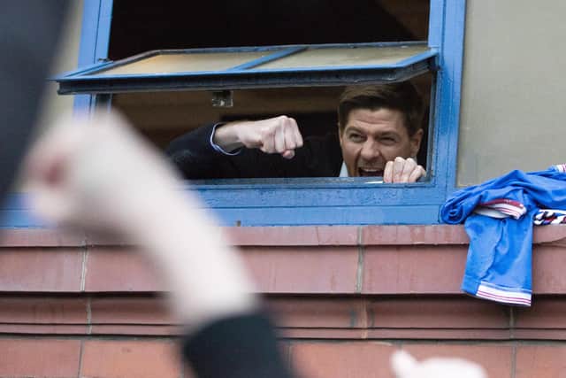 Rangers manager Steven Gerrard hangs out the window of the dressing room to cheer with fans gathered outside the stadium after the Scottish Premiership match at Ibrox Stadium, Glasgow.