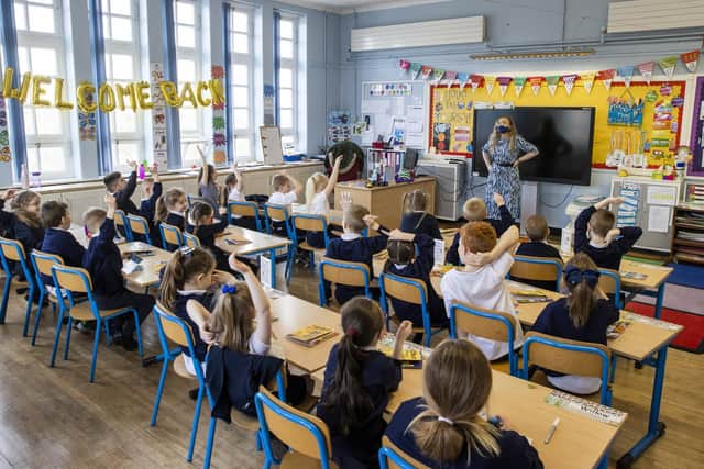 P3 teacher Jessica Cargill with her class at Springfield Primary School in Belfast. Today marks the first day back for Pre-school, nursery and primary school pupils in P1-P3 have returned to classrooms across Northern Ireland.