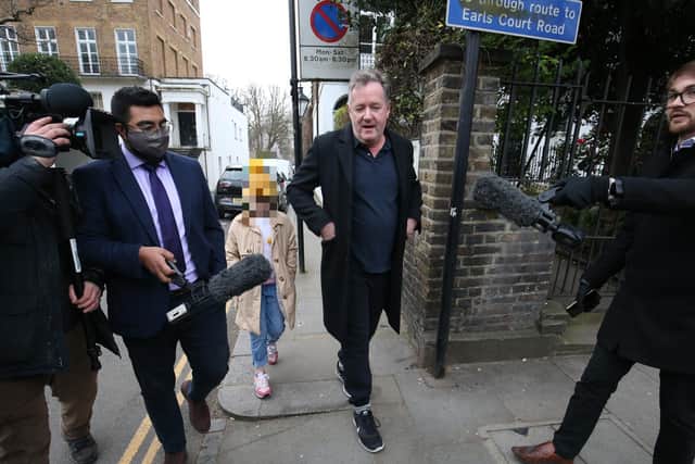 Piers Morgan takes questions from the media while walking his daughter to school in London on Wednesday morning.