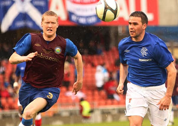David Healy and Linfield's David Armstrong  during  a fundraising match on May Day at Windsor Park in 2012