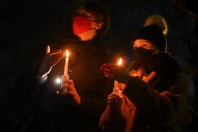 Members of the public hold candles as they gather for a vigil for Sarah Everard at the bandstand on Clapham Common on March 13, 2021 in London