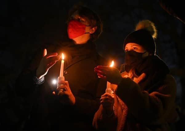 Members of the public hold candles as they gather for a vigil for Sarah Everard at the bandstand on Clapham Common on March 13, 2021 in London