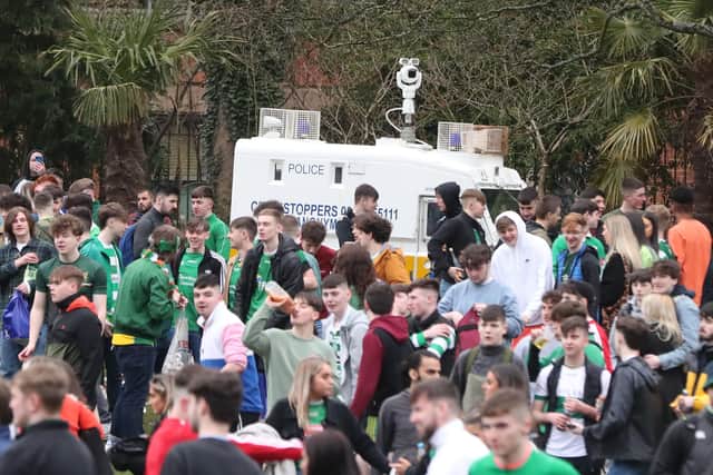 A police vehicle surrounded by people out celebrating in the Botanic Gardens in Belfast, on St Patrick's Day. Picture date: Wednesday March 17, 2021.