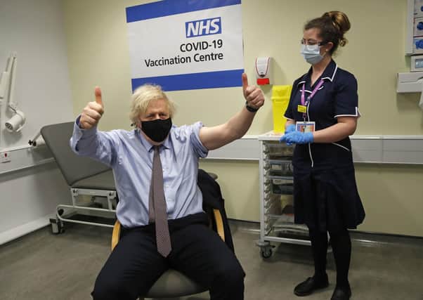 Prime Minister Boris Johnson gives thumbs up after receiving the first dose of AstraZeneca vaccine administered by nurse and Clinical Pod Lead, Lily Harrington at Westminster Bridge Vaccination Centre at St Thomas' Hospital in London.