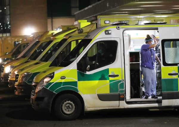 PACEMAKER,BELFAST, 15/12/2020:  A nurse at Antrim Area Hospital waves to a patient who was waiting to be admitted in one of the rows of ambulances in the car park, 
PICTURE BY STEPHEN DAVISON