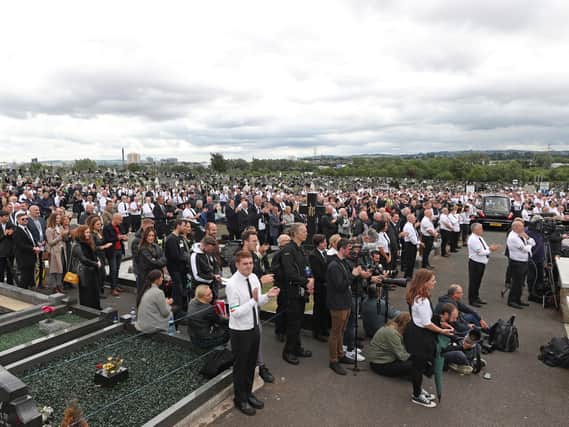 Crowds gathered in Milltown Cemetery for the funeral of Bobby Storey. Mr. Storey's coffin was then taken to Roselawn Crematorium.