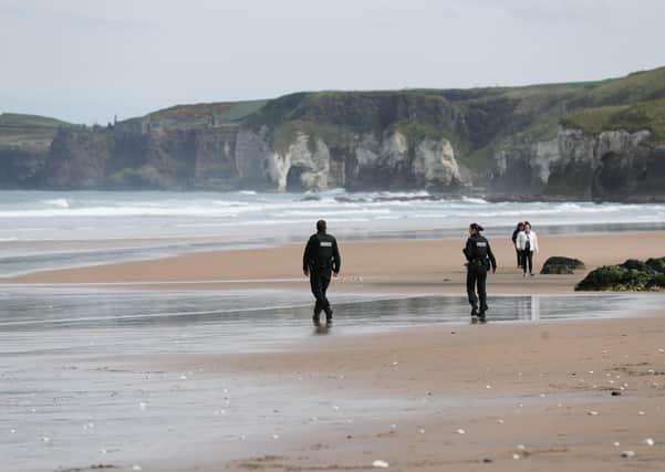 The PSNI – seen here on an almost empty White Rocks beach last Easter – have enforced restrictions vigorously, yet let the Bobby Storey funeral. 

Photo: Kelvin Boyes/Press Eye.