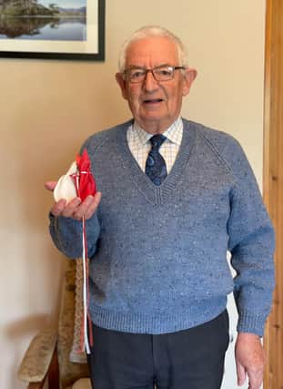 Neville Pogue from County Armagh holding his gift of Maundy money