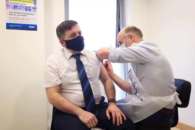 Handout photo issued by Press Eye of Health Minister Robin Swann receiving his first coronavirus vaccine from pharmacist Stephen Burns at the Ballee Pharmacy in Ballymena