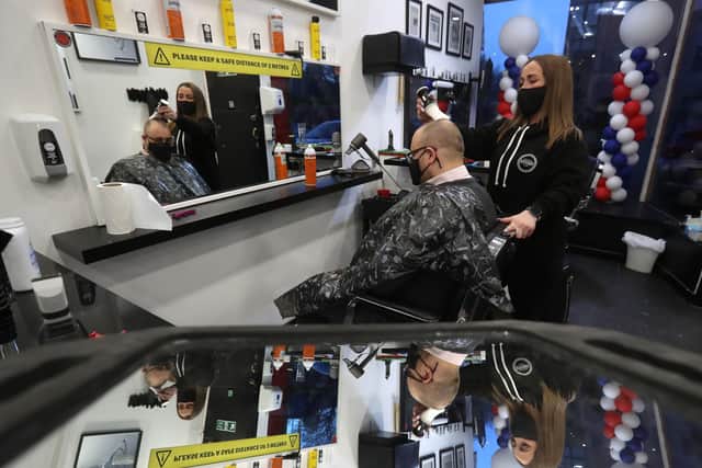 Barber Maggie McGillivray trims Sam Rosenblom's hair at Tony Mann's Barber Shop in Giffnock near Glasgow as barbers reopen across Scotland on Easter Monday. Photo: Andrew Milligan/PA Wire
