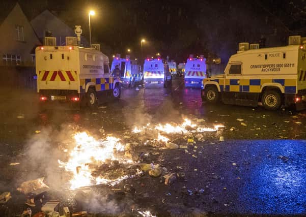 PSNI Tactical Support Group (TSG) officers in attendance at the Loyalist Nelson Drive Estate in the Waterside of Londonderry, during a public order incident which saw a car being set alight and surrounding roads being blocked with fires. Photo: Liam McBurney/PA Wire