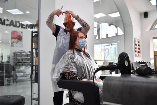 Senior stylist Robert Brooks cuts the hair of Carmen Smith at the Lazarou salon in Cardiff, Wales. Hairdressers and barbers in Wales reopened last month. Picture date: Monday March 15, 2021.