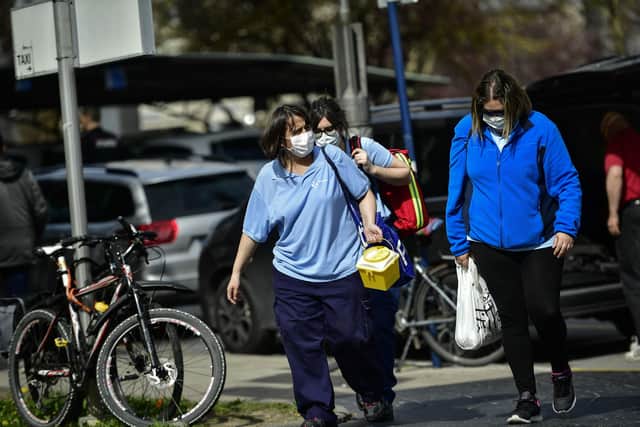 Staffs members at Txagorritxu Hospital protect their faces with masks while arriving at the hospital, in Vitoria, northern Spain, Tuesday, March 10, 2020. Spain's health minister on Monday announced a sharp spike in coronavirus cases in and around the national capital (AP Photo/Alvaro Barrientos)
