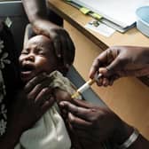 A mother holds her baby for a malaria vaccine in Kenya. The disease killed 270,000 children under the age of five in 2018