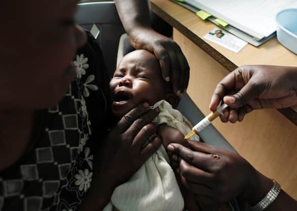 A mother holds her baby for a malaria vaccine in Kenya. The disease killed 270,000 children under the age of five in 2018