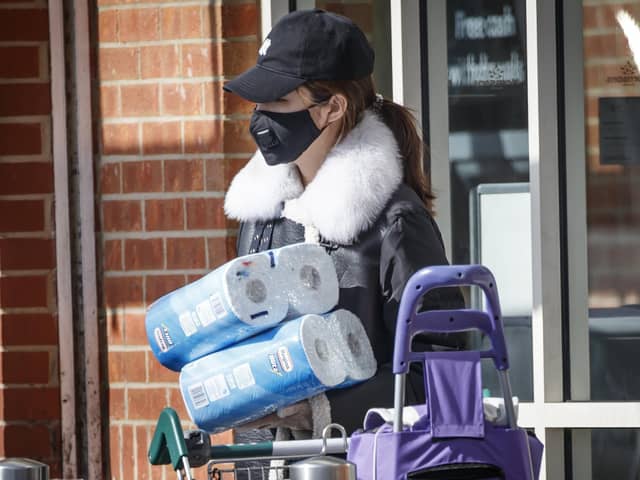 A woman wearing a face mask and protective gloves with supplies at a supermarket as shoppers purchase supplies amid the coronavirus pandemic. (Photo: PA Wire)
