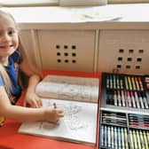 Poppy Ashton with her colouring book and pencils