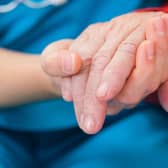 Generic photo of nurse holding the hand of an elderly woman.