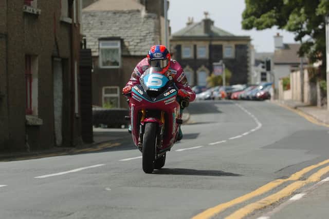 Flat to the tank, Ryan Farquhar powers through Kirk Michael village on his way to victory in the 2004 Junior TT.