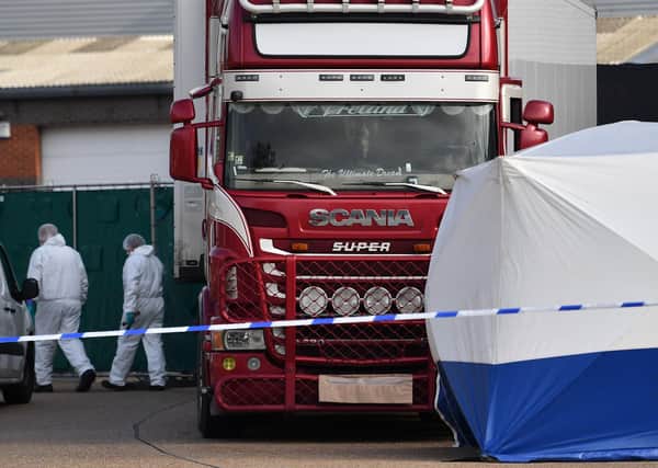 Police officers in a forsensic suits are photographed at the scene with a lorry, believed to have originated from Bulgaria, and found to be containing 39 dead bodies, inside a police cordon after being discovered at Waterglade Industrial Park in Grays, east of London, on October 23, 2019