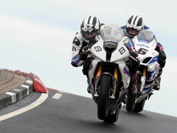 Michael Dunlop (BMW) leads William Dunlop (Tyco Suzuki) on the final lap of the opening Superbike race at the 2014 North West 200.