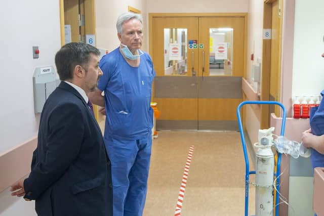 Health Minister Robin Swann with Dr Tom Black and a staff member during the Minister's visit to the Covid-19 Centre at Altnagelvin Hospital