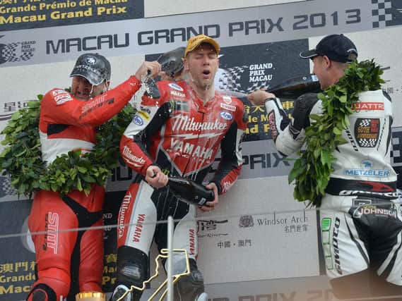 Ian Hutchinson is soaked in the victory champagne by runner-up Michael Rutter (left) and Gary Johnson after winning the 2013 Macau Grand Prix.