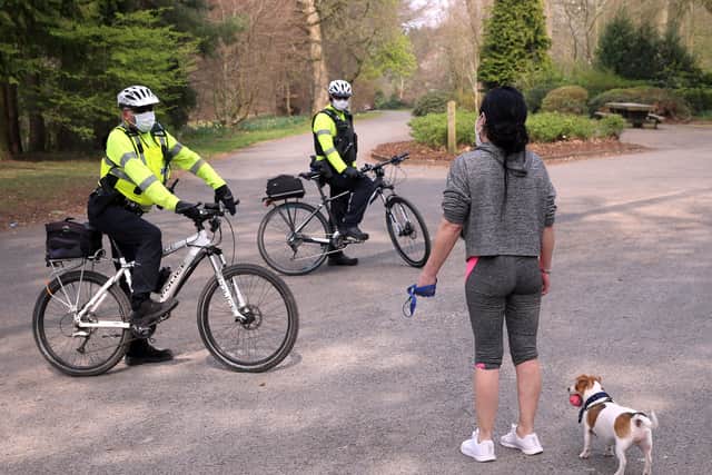 The new normal ... PSNI officers wearing protective masks talk to a woman walking her dog in Belfast’s Ormeau Park last week