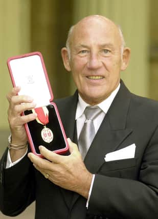 Sir Stirling Moss in 2000 after he received his Knighthood from the Prince of Wales at an Investiture at Buckingham Palace. Pic by PA.